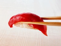 握り寿司を箸でつまむ写真